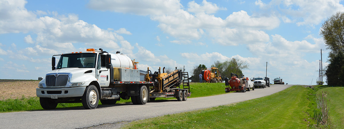 American Fiber Construction trucks parked along road at job site