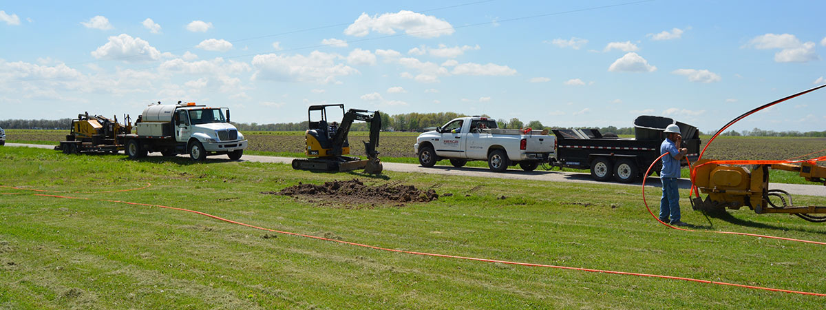 construction crew installing cable along a country road