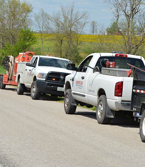 American Fiber Construction trucks and equipment parked along road