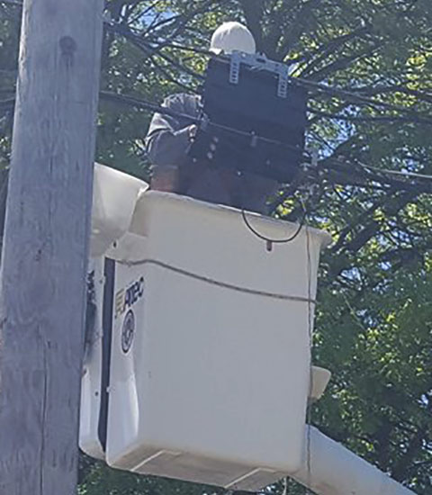 service tech using a bucket truck to work on a splicing project